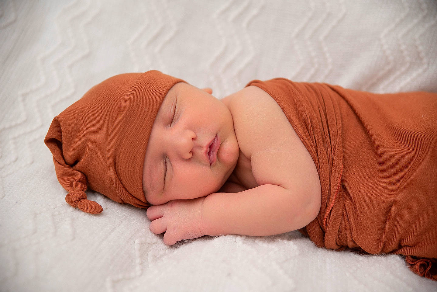 Rhyan is registered to the contest to win money with this photo: arm, baby, baby_sleeping, baby_toddler_clothing, bedding, bedtime, cheek, child, comfort, eye, face, hand, head, headgear, headwear, human_body, linens, nose, person, skin