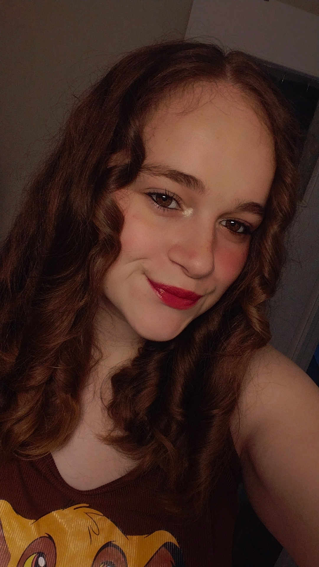Julie participe au concours pour gagner de l'argent avec cette photo : person, female, curly_hair, smile, tank_top, indoor, portrait, young_person, brown_hair, makeup, lipstick, casual_clothing, face, eyebrows, skin, shoulder, selfie, light, expression, cartoon_character