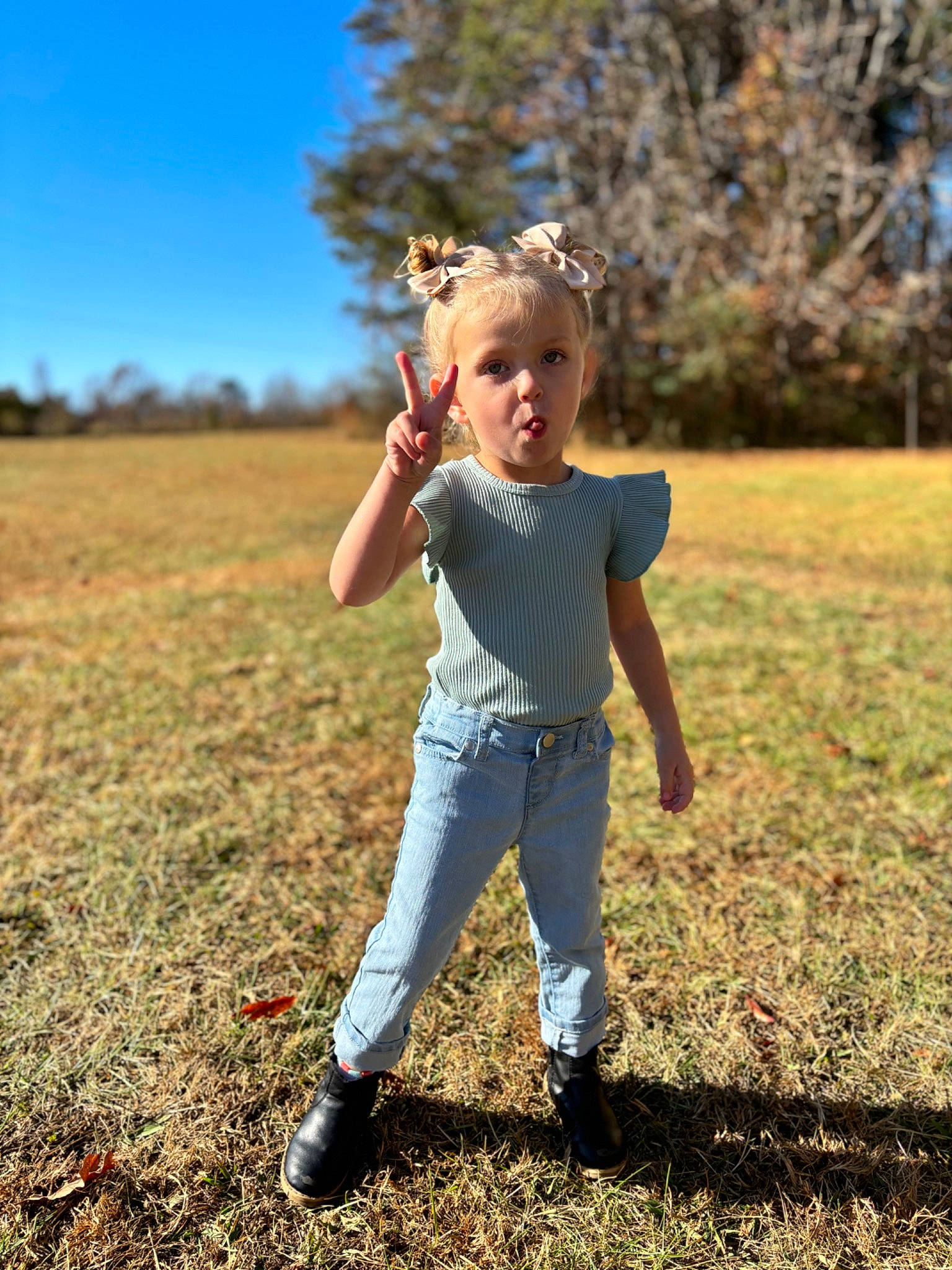 Tatum is registered to the contest to win money with this photo: denim, field, flash_photography, fun, gesture, grass, grassland, happy, jeans, landscape, leisure, meadow, people_in_nature, person, plant, prairie, sky, soil, toddler, tree