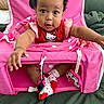 Nola joined the competition — help win amazing prizes! baby, child, pink, hello_kitty, socks, curly_hair, seat, toy, polka_dots, red, cute, infant, smiling, indoor, person, clothing, playful, expression, toddler, face