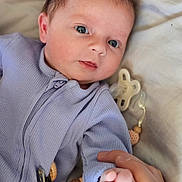 Oakley joined the competition — help win amazing prizes! baby, infant, hand, finger, pacifier, onesie, purple_clothing, face, eyes, skin, blanket, beads, clip, closeup, indoor, person, newborn, cute, soft, grip