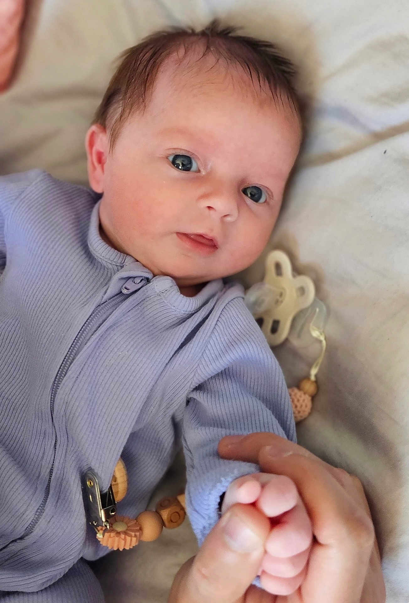 Oakley joined the competition — help win amazing prizes! baby, infant, hand, finger, pacifier, onesie, purple_clothing, face, eyes, skin, blanket, beads, clip, closeup, indoor, person, newborn, cute, soft, grip
