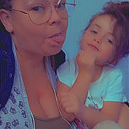 Kathalia a rejoint le concours — aidez-le/la à gagner de superbes lots ! woman, child, glasses, tongue_out, casual_clothing, indoor, portrait, playful, fun, family, person, smile, face, hair, holding, tshirt, light, blue_background, skin, expression