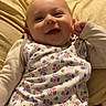 Forrestt is registered to the contest to win money with this photo: baby, smiling, infant, cushion, indoors, clothing, patterned_outfit, happy, face, child, bedroom, blanket, relaxed, lying_down, cute, baby_garment, skin, person, head, comfort