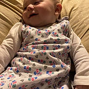 Forrestt joined the competition — help win amazing prizes! baby, infant, sleepwear, pillow, smile, child, indoors, cute, relaxing, patterned_clothing, face, sleeping_bag, home, soft_light, young_child, person, comfort, candid, portrait, resting
