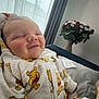 Noé participe au concours pour gagner de l'argent avec cette photo : baby, smile, indoor, onesie, winnie_the_pooh, curtain, window, flower_bouquet, red_roses, white_flowers, couch, blanket, soft_lighting, child, happy, infant, cozy, person, portrait, relaxing
