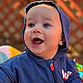 baby, child, hoodie, blue_clothing, smiling, happy, face, portrait, outdoor, daylight, infant, expression, cute, warm_light, closeup, person, young_child, casual_clothing, playful, joyful