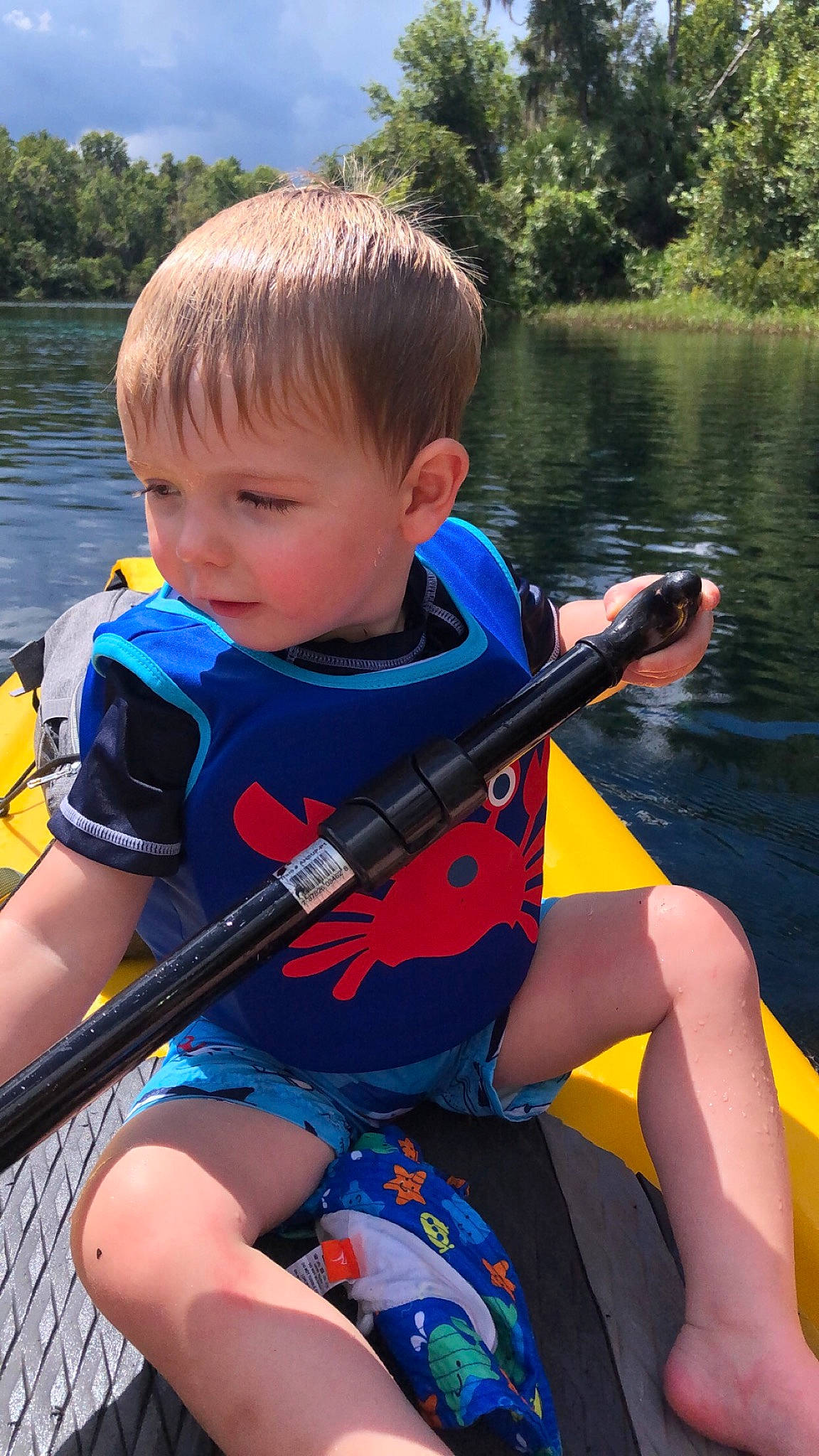 Mac is registered to the contest to win money with this photo: boat, boating, boats_and_boating_equipment_and_supplies, child, kayak, leisure, lifejacket, oar, person, personal_protective_equipment, play, recreation, river, toddler, vacation, vehicle, watercraft, watercraft_rowing