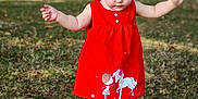 Marina participe au concours pour gagner de l'argent avec cette photo : child, toddler, red_dress, sandals, grass, outdoor, nature, cute, balance, summer, sunlight, young_child, person, standing, cartoon_print, dress, barefoot, greenery, daylight, playful