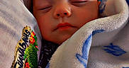 Zane is registered to the contest to win money with this photo: baby, sleeping, infant, portrait, face, closed_eyes, blanket, swaddled, bed, cozy, indoors, resting, peaceful, child, newborn, textile, cushion, soft, photography, closeup