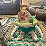 Zane joined the competition — help win amazing prizes! baby, child, infant, portrait, sitting, jumper, activity_center, wide_eyed, indoors, living_room, bedroom, couch, bed, blanket, rug, carpet, baby_clothing, onesie, smiling, home