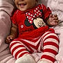 baby, infant, smiling, red_clothing, striped_leggings, minnie_mouse, cute, child, soft_blanket, cozy, happy, portrait, toddler, playful, socks, indoors, young_child, comfortable, resting, adorable