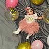 Ysabella is registered to the contest to win money with this photo: baby, balloon, clothing, dress, face, footwear, hat, head, hosiery, newborn, people, person, photography, portrait, purple, shoe, sitting, skirt, sock, sphere
