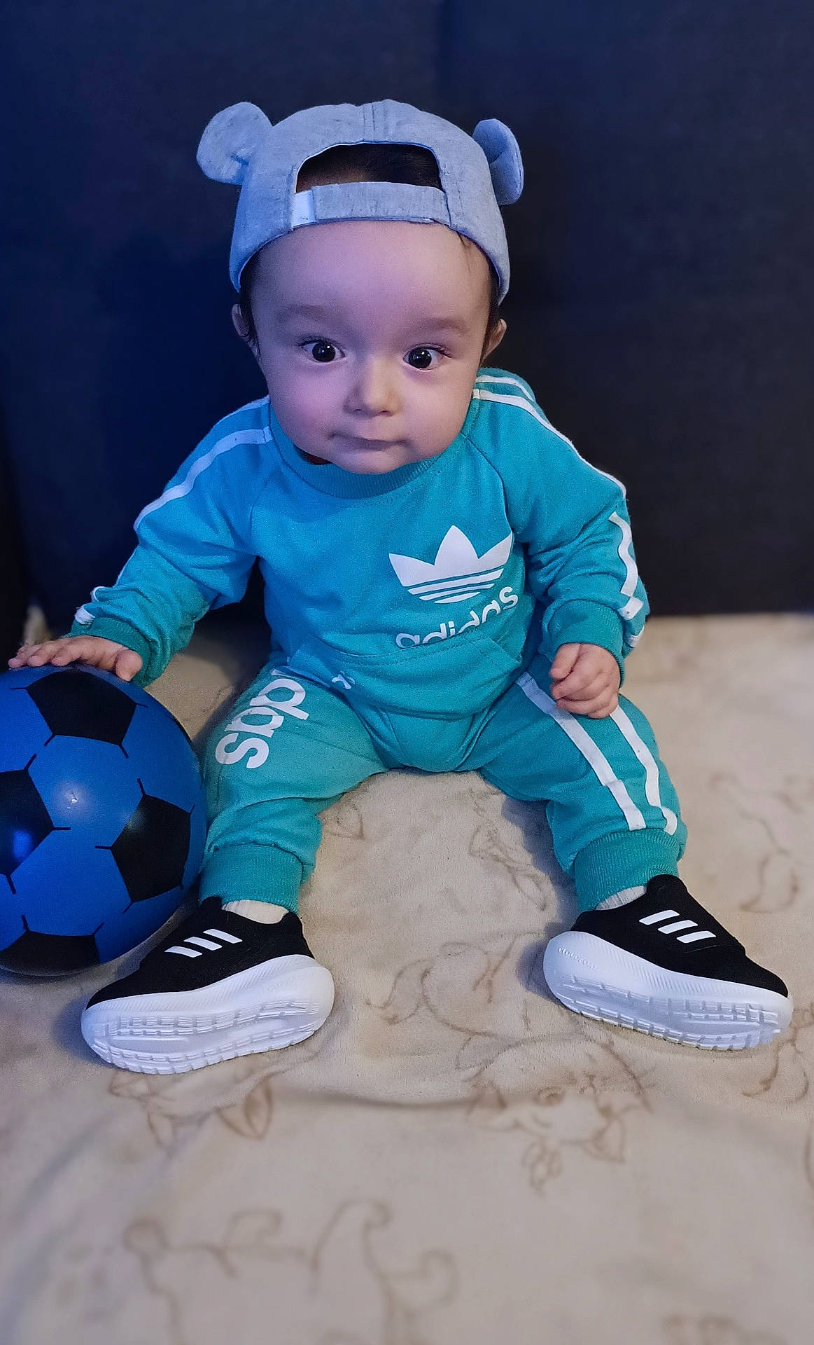 Gabriel participe au concours pour gagner de l'argent avec cette photo : baby, ball, bodypart, clothing, face, finger, football, footwear, hand, head, pants, person, photography, portrait, shoe, sneaker, soccer, soccerball, sphere, sport