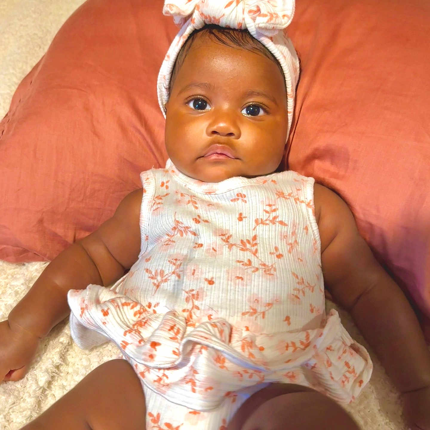 Nelliana joined the competition — help win amazing prizes! adorable, arms, baby, child, closeup, clothing, cute, face, floral_outfit, headband, headwear, indoors, infant, legs, lying_down, pillow, portrait, serious_expression, skin, soft_surface