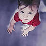 child, baby, infant, toddler, red_clothing, onesie, face, eyes, looking_up, hands, palms, hair, portrait, closeup, top_view, curious_expression, soft_focus, indoor, floor, candid