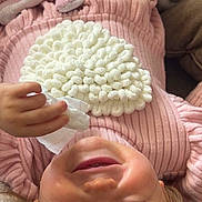 Eva a rejoint le concours — aidez-le/la à gagner de superbes lots ! child, upside_down, smiling, pink_sweater, tissue, blanket, cushion, indoor, cozy, playful, young_child, face, hand, hair, comfort, portrait, closeup, soft_texture, happy, relaxed