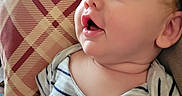 Cairo is registered to the contest to win money with this photo: baby, blue_eyes, cheeks, child, closeup, curious, cushion, expression, face, head, indoors, infant, mouth, pattern, person, portrait, seated, skin, soft_lighting, striped_shirt