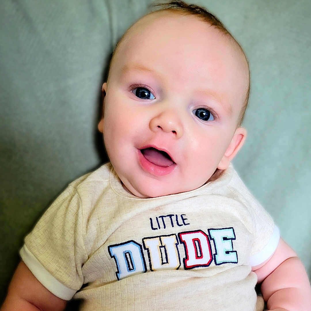 Cairo is registered to the contest to win money with this photo: baby, baby_fashion, blue_eyes, child, closeup, clothing, cute, face, happy, head, indoors, infant, person, portrait, shirt, sitting, skin, smile, soft_background, young