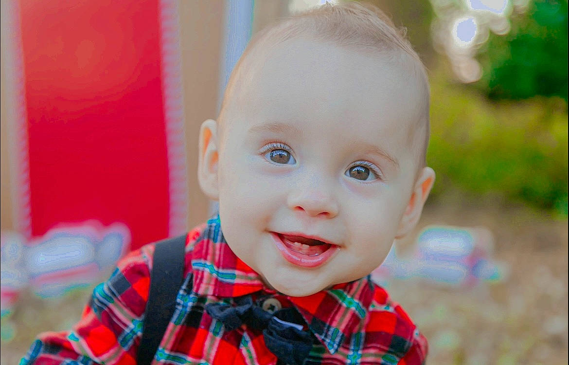 Lane is registered to the contest to win money with this photo: baby, baby_toddler_clothing, cheek, child, eye, happy, human_body, iris, joy, lip, mouth, nose, pattern, person, plaid, plant, red, skin, sleeve, smile