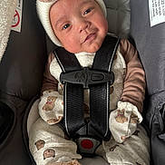 Santiago joined the competition — help win amazing prizes! baby, child, car_seat, seat_belt, hat, knit_hat, clothing, mittens, footwear, plush_toy, cute, smile, portrait, indoor, infant, straps, safety, teddy_bear_pattern, person, closeup