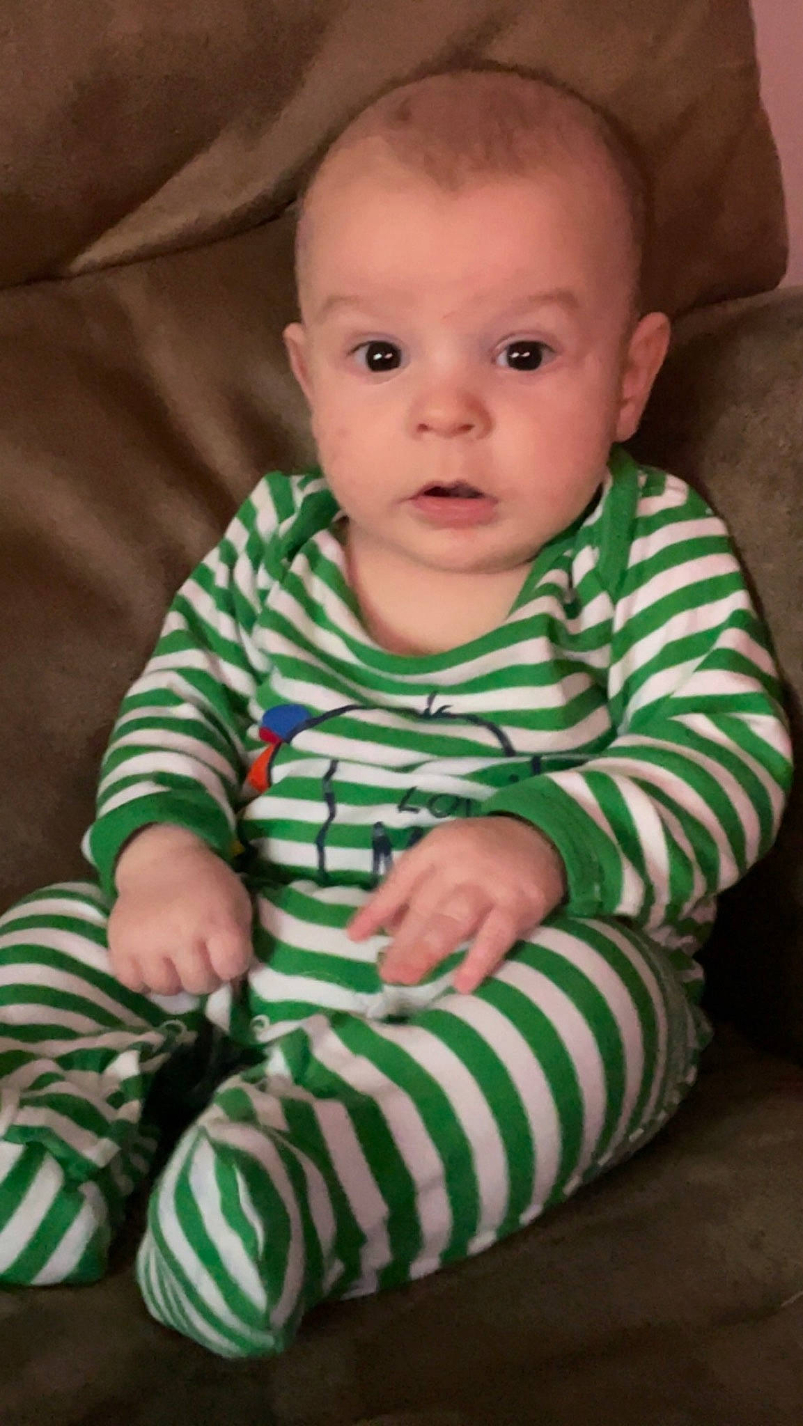 Tatum is registered to the contest to win money with this photo: arm, baby, baby_toddler_clothing, cheek, child, comfort, finger, flooring, hand, head, iris, linens, lip, nose, person, sitting, skin, sleeve, smile, surprise