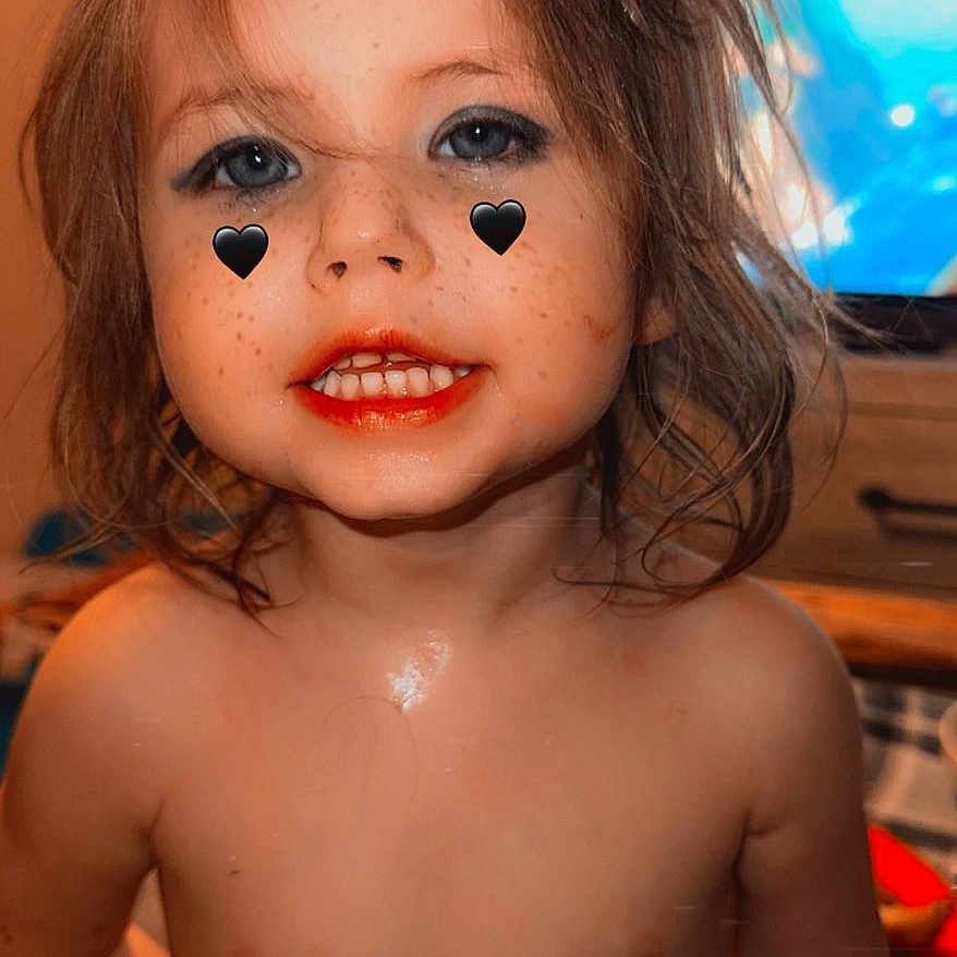 Isabella is registered to the contest to win money with this photo: child, toddler, smiling, face, hair, heart_stickers, freckles, indoor, television, furniture, shirtless, skin, eyes, mouth, person, portrait, cute, messy_hair, home, expression