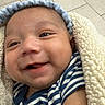 Samuel joined the competition — help win amazing prizes! baby, smiling, striped_shirt, headband, blanket, cozy, tiled_floor, face, infant, happy, child, person, closeup, cute, indoor, soft_texture, wearing, portrait, newborn, wrapped