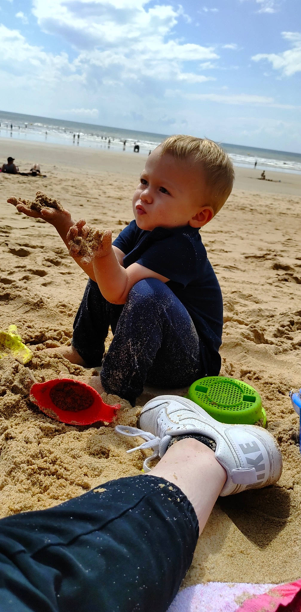 Tyago participe au concours pour gagner de l'argent avec cette photo : beach, child, cloud, fun, hairstyle, happy, holiday, human, leg, leisure, people_in_nature, people_on_beach, person, sand, sitting, sky, sneakers, toddler, travel, water