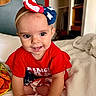 Lilia joined the competition — help win amazing prizes! baby, child, infant, smile, crawling, red_clothing, headband, bow, bed, blanket, indoor, person, cute, happy, face, eyes, skin, hand, patriotic, american_flag_colors