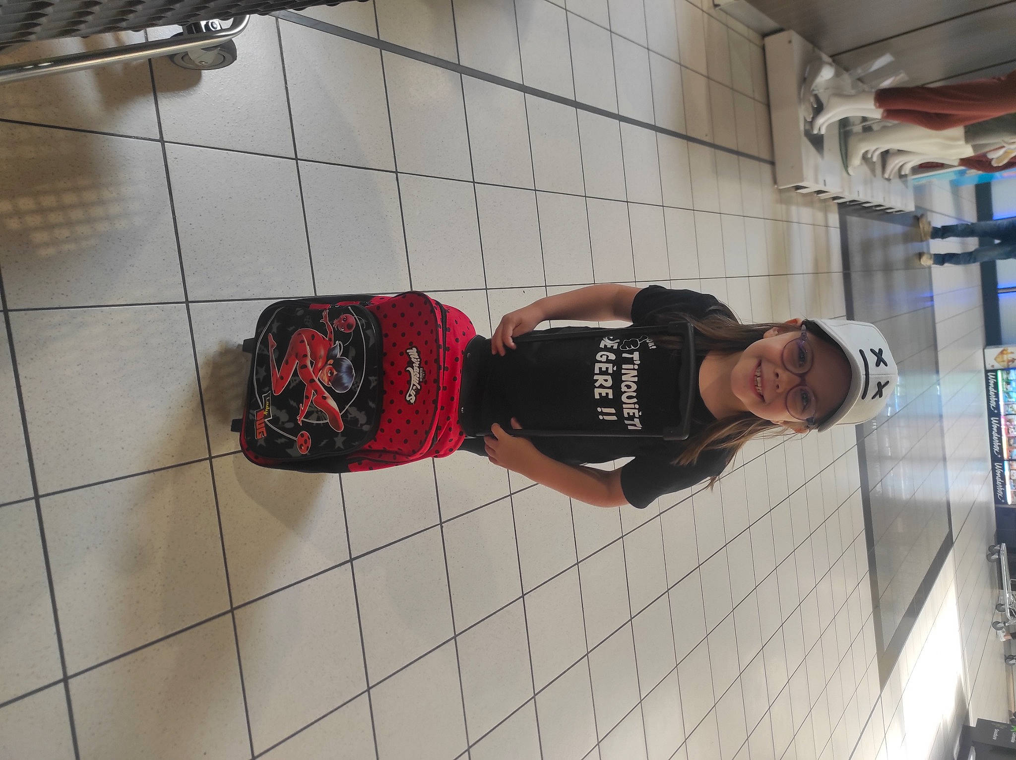 Maylis participe au concours pour gagner de l'argent avec cette photo : building, flooring, hat, headwear, human_leg, joy, knee, pattern, person, plaid, sleeve, smile, t_shirt, tartan, thigh, waist