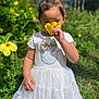 child, cute, daylight, dress, flower, garden, greenery, happy, nature, outdoor, person, plants, playful, portrait, summer, sunlight, toddler, white_dress, yellow_flower, young_child