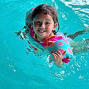 Jayani is registered to the contest to win money with this photo: blue, child, cute, floaties, fun, gesture, happy, kid, leisure, outdoor_activity, person, playful, recreation, smiling, splash, summer, swimming_pool, water, watermelon_pattern, wet_hair