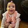 baby, bib, child, couch, cute, face, furniture, hair_bow, happy, home, indoor, infant, pink_clothing, portrait, sitting, smiling, socks, warm_lighting, white_shirt, wooden_floor