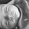 baby, sleeping, infant, portrait, black_and_white, close_up, face, closed_eyes, peaceful, resting, blanket, swaddled, clothing, indoor, cozy, calm, soft_lighting, photography, newborn, candid