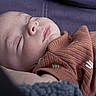 newborn, baby, sleeping, portrait, close_up, face, indoors, blanket, clothing, cozy, peaceful, resting, infant, skin, eyes_closed, nose, lips, soft_lighting, textile, bed
