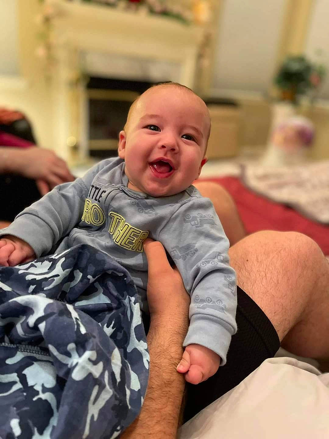 Jonathan is registered to the contest to win money with this photo: baby, baby_toddler_clothing, cheek, child, comfort, elbow, event, facial_expression, fun, gesture, happy, linens, person, room, sitting, skin, smile, t_shirt, thigh, toddler
