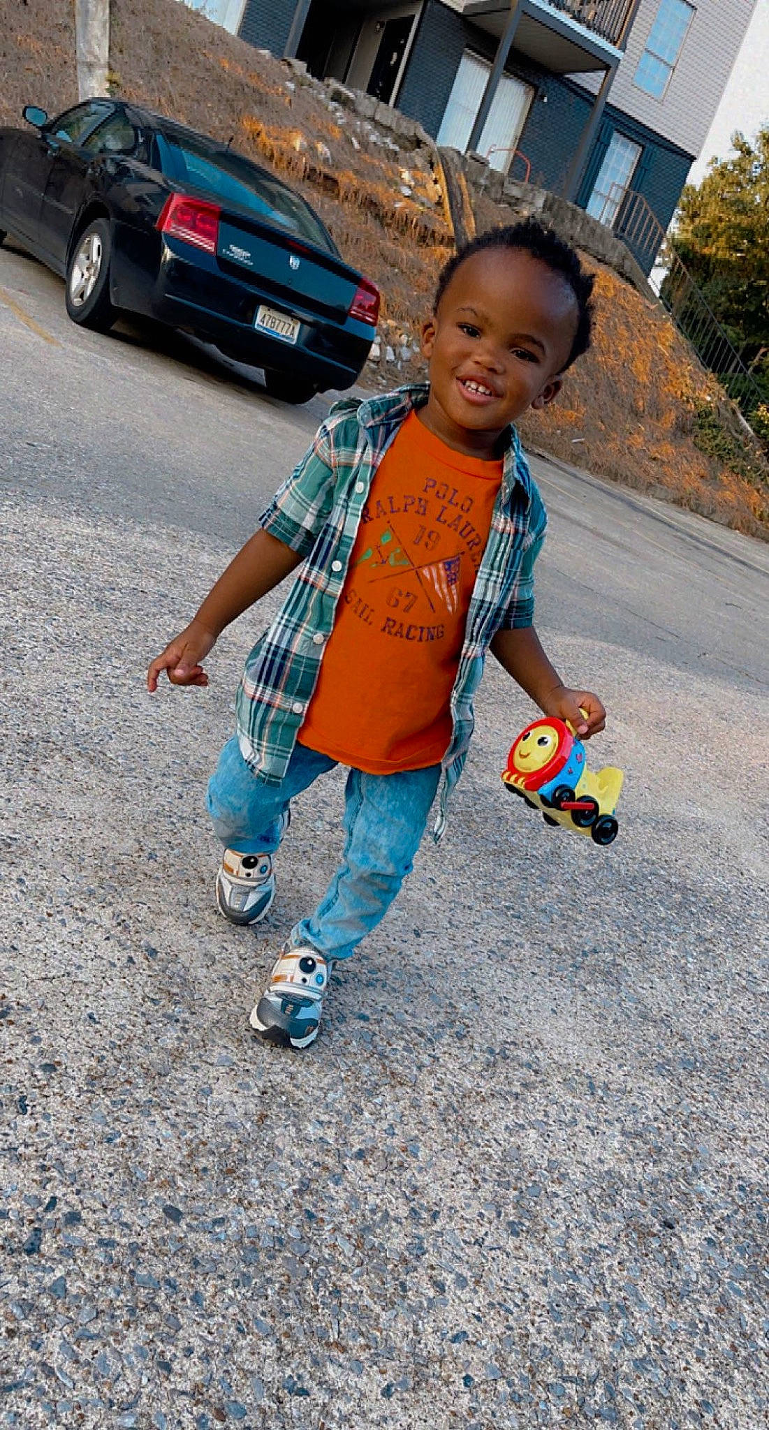 Amari is registered to the contest to win money with this photo: asphalt, automotive_exterior, car, child, electric_blue, face, family_car, fun, happy, joy, leisure, mid_size_car, person, plant, recreation, road, smile, soil, t_shirt, toddler