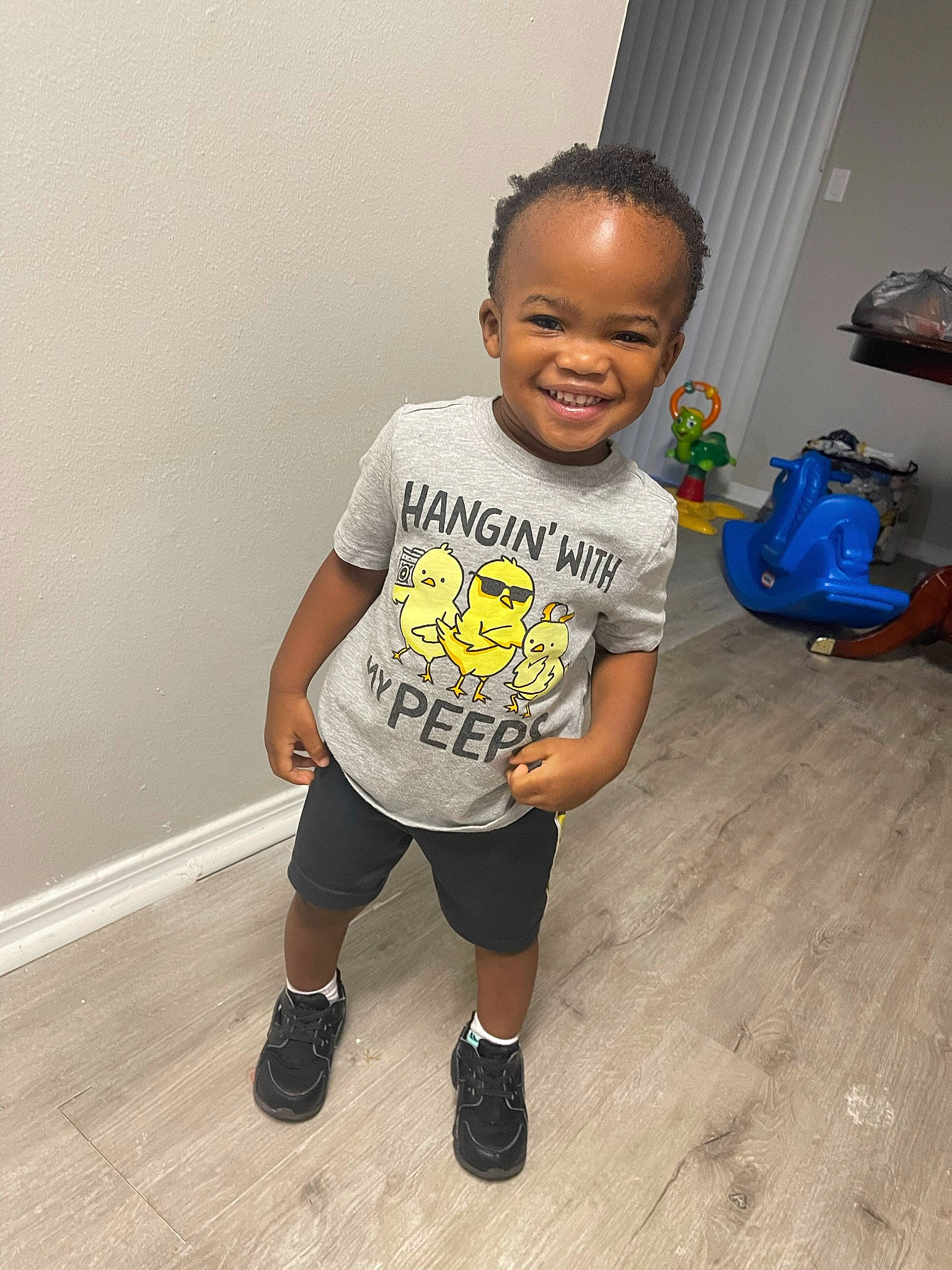 Amari is registered to the contest to win money with this photo: arm, baby_toddler_clothing, child, electric_blue, floor, flooring, fun, happy, hardwood, head, joint, joy, knee, luggage_and_bags, person, shorts, sleeve, smile, sportswear, standing