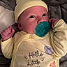 baby, infant, pacifier, yellow_clothing, hat, blanket, cute, sleepwear, newborn, face, hand, lying_down, soft_texture, plush, child, indoors, portrait, expression, comfort, cozy
