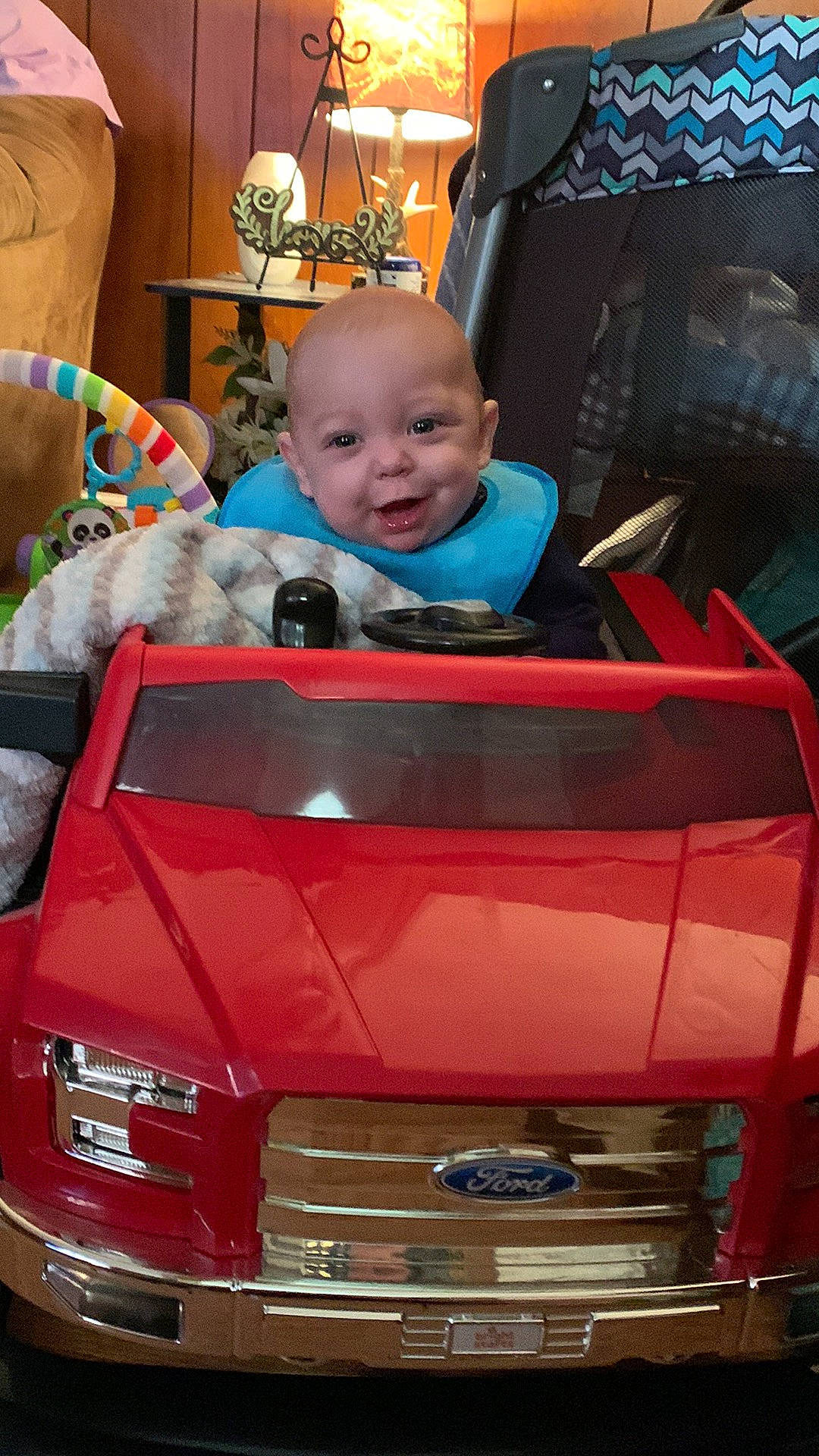 Colton is registered to the contest to win money with this photo: automotive_design, automotive_exterior, automotive_lighting, automotive_tire, baby, baby_toddler_clothing, blue, bumper, car, grille, hood, motor_vehicle, person, personal_luxury_car, photograph, product, smile, snapshot, toddler, vehicle