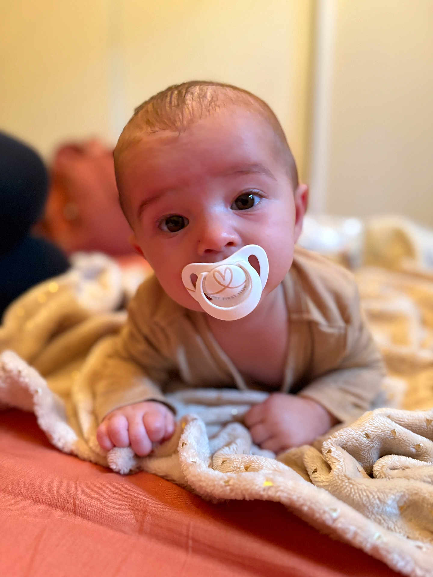 Noah a rejoint le concours — aidez-le/la à gagner de superbes lots ! baby, pacifier, blanket, infant, face, hand, bed, soft_focus, cute, child, lying_down, indoors, warm_colors, expression, person, skin, head, clothing, comfort, closeup