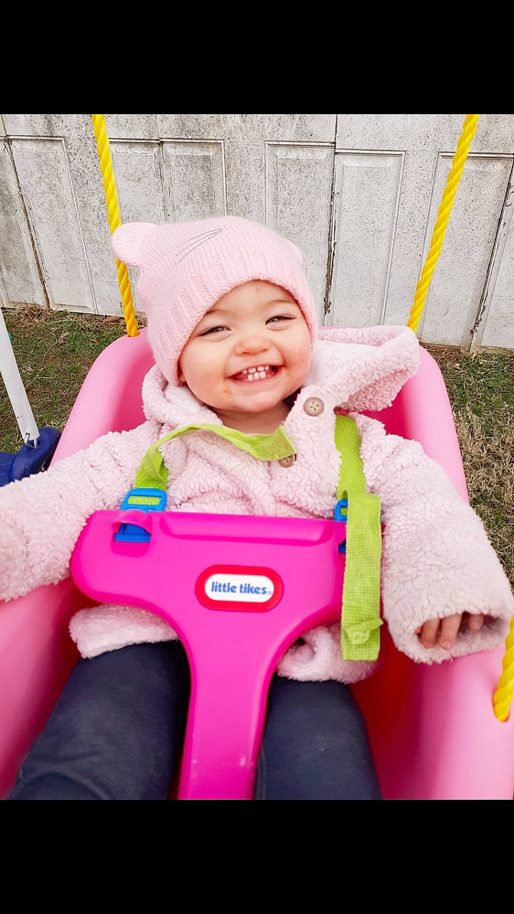 Bethanie joined the competition — help win amazing prizes! baby, child, fun, happy, headwear, joy, outdoor_play_equipment, person, pink, play, product, riding_toy, smile, swing, toddler, vehicle
