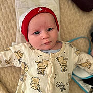 Owenn a rejoint le concours — aidez-le/la à gagner de superbes lots ! baby, infant, beanie, hat, onesie, baby_clothes, bear_pattern, blanket, lying_down, face, expression, indoor, cute, child, person, soft_lighting, texture, portrait, warm_colors, headwear