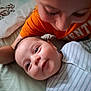 James is registered to the contest to win money with this photo: baby, bed, blanket, child, closeup, cute, face, family, happy, indoor, infant, orange_shirt, pajamas, person, sibling, skin, sleepwear, smile, striped_clothing, toddler