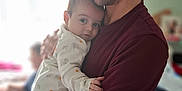 James is registered to the contest to win money with this photo: baby, blurred_background, caring, casual_clothing, child, closeup, elephant_print, family, holding, home, hugging, indoor, infant, love, man, pajamas, person, portrait, tenderness, young_adult