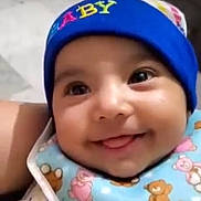 Aditi Joshi is registered to the contest to win money with this photo: baby, smiling, blue_hat, bib, teddy_bear_pattern, cute, infant, child, face, happy, tongue_out, closeup, apparel, headwear, indoors, person, portrait, young_child, adorable, bright_eyes