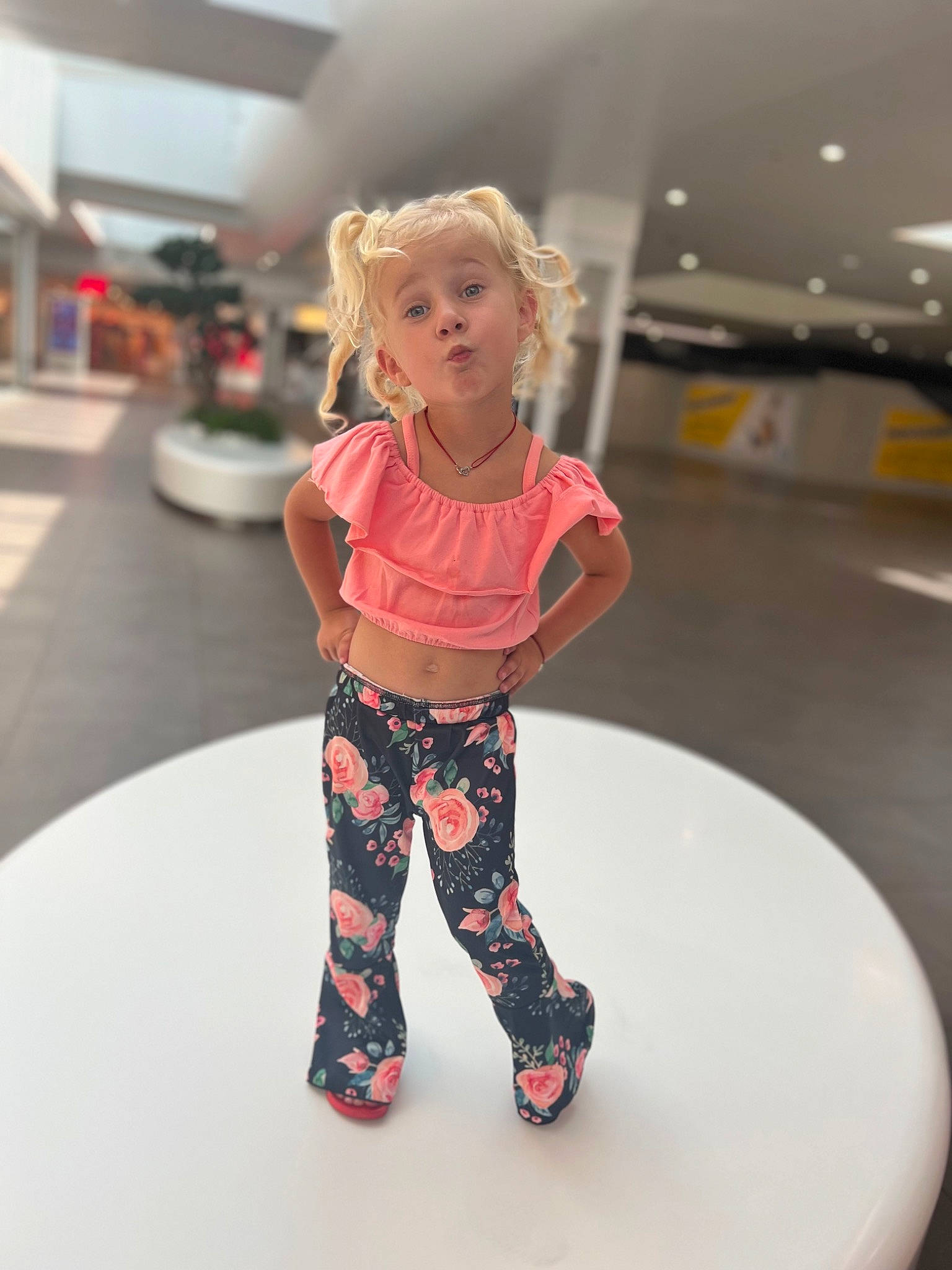 Taïly participe au concours pour gagner de l'argent avec cette photo : blond, brown_hair, carmine, event, fashion_design, floor, flooring, fun, human_leg, joint, knee, long_hair, pattern, person, sandal, sleeve, sportswear, standing, thigh, toy