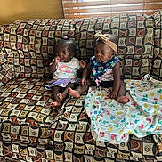 Zamyra Zamirah is registered to the contest to win money with this photo: baby, babies, child, children, couch, sofa, blanket, headband, patterned_fabric, indoors, window_blinds, carpet, foot, sitting, curious, clothing, person, two_people, home_interior, cute