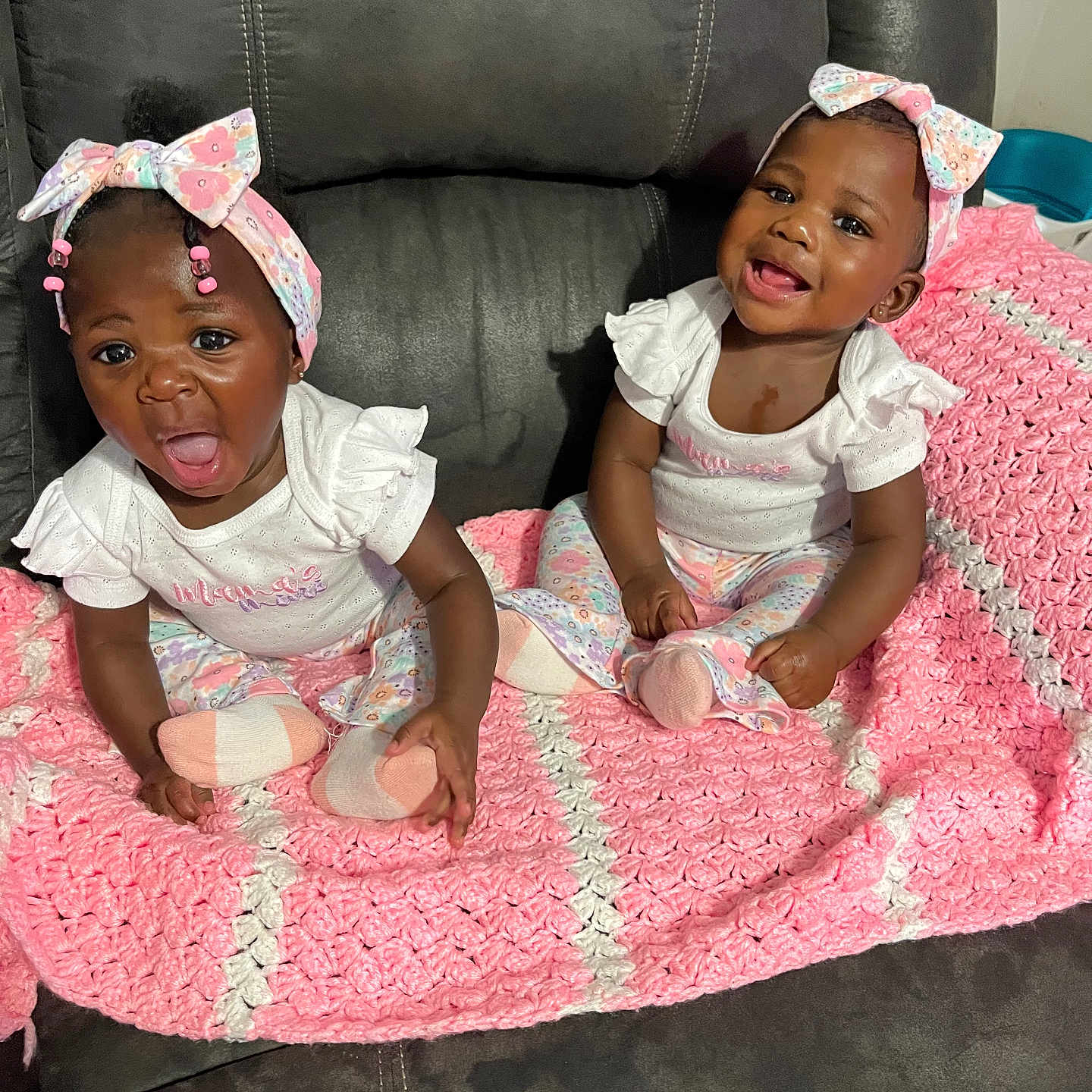 Zamyra Zamirah is registered to the contest to win money with this photo: baby, infant, child, toddler, smiling, yawning, headband, bow, matching_clothes, white_top, patterned_pants, pink_blanket, crocheted_blanket, couch, leather_couch, indoor, cute, happy, sibling, playful